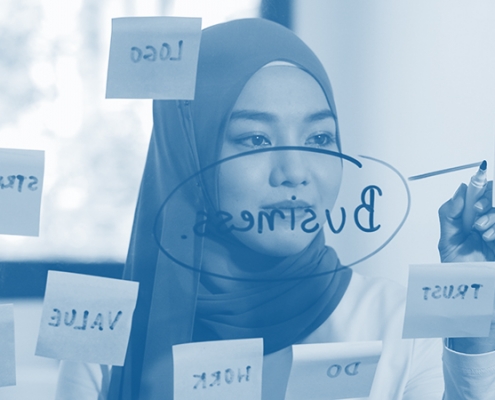 a woman writing ideas on a board